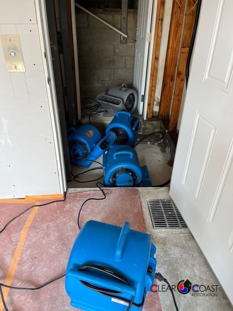 Blue air movers placed on a floor for water damage restoration in a residential space.
