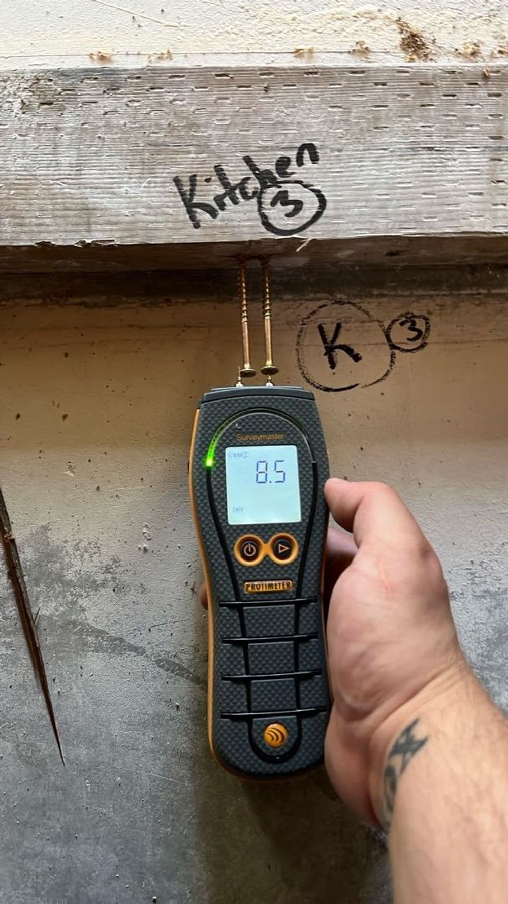 Moisture meter reading 8.5 in kitchen area, showing signs of potential water damage.