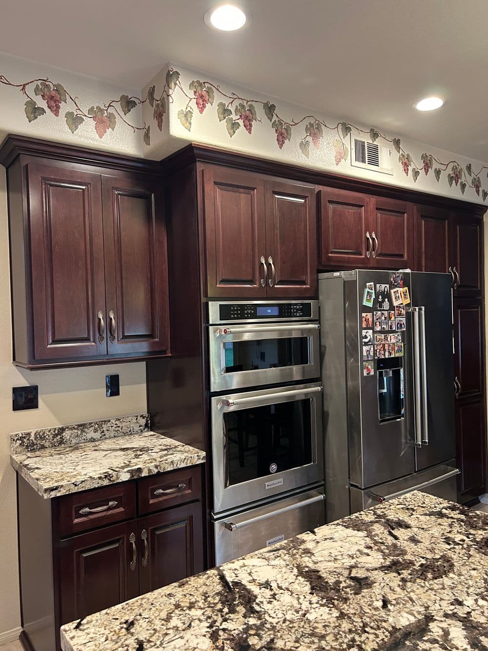 Modern kitchen with dark wood cabinets, stainless steel appliances, and granite countertops.